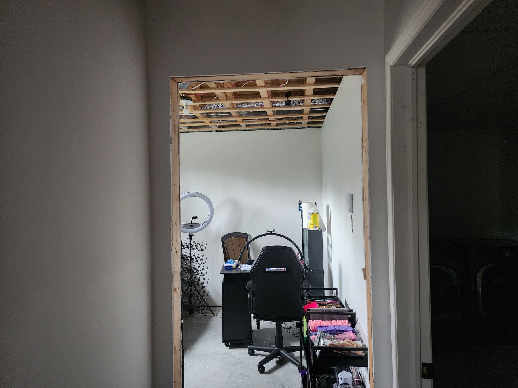 Nouvelle ouverture percée dans une cloison, encadrement de bois en place et plafond encore ouvert sur les solives.